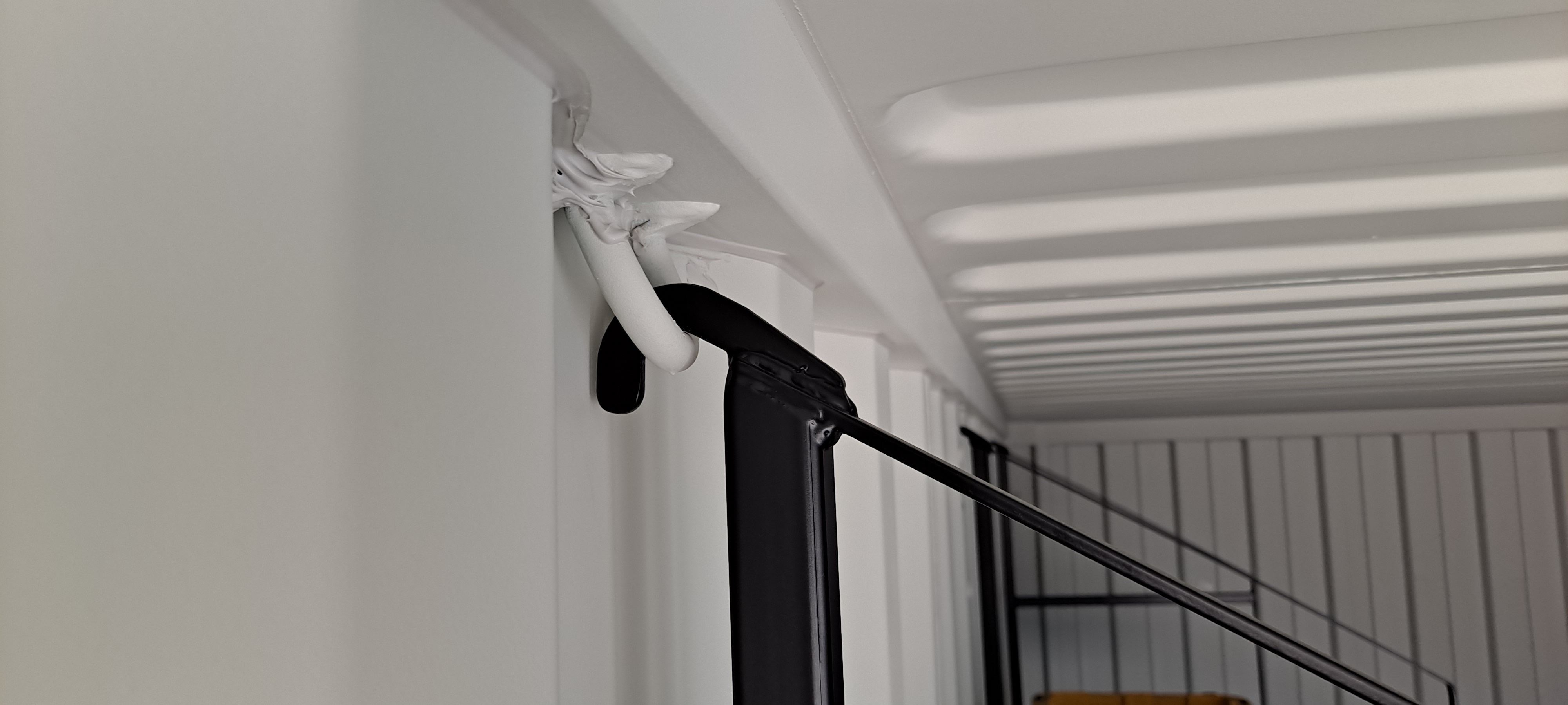 Close-up view of a shelving bracket set installed inside a shipping container, showing metal brackets attached to the container wall.
